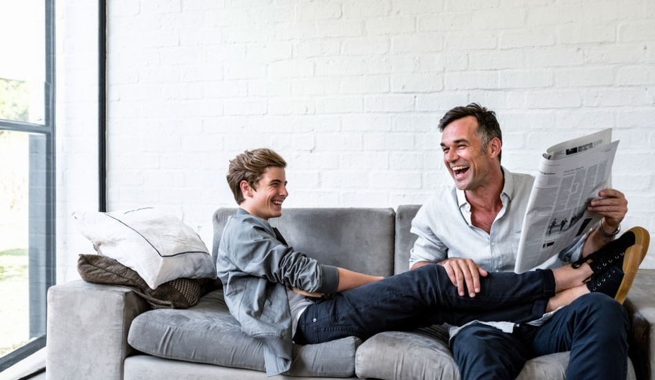 Father and teenage son on couch